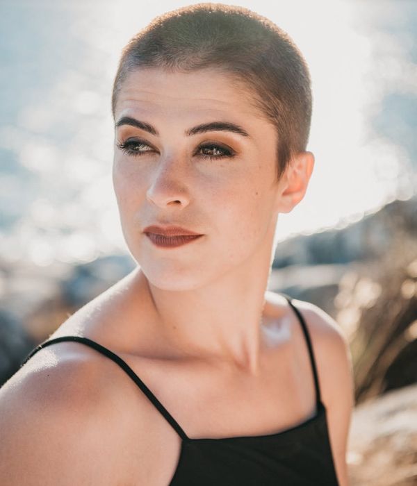 Person stretching gently outdoors with the sun setting in the background.